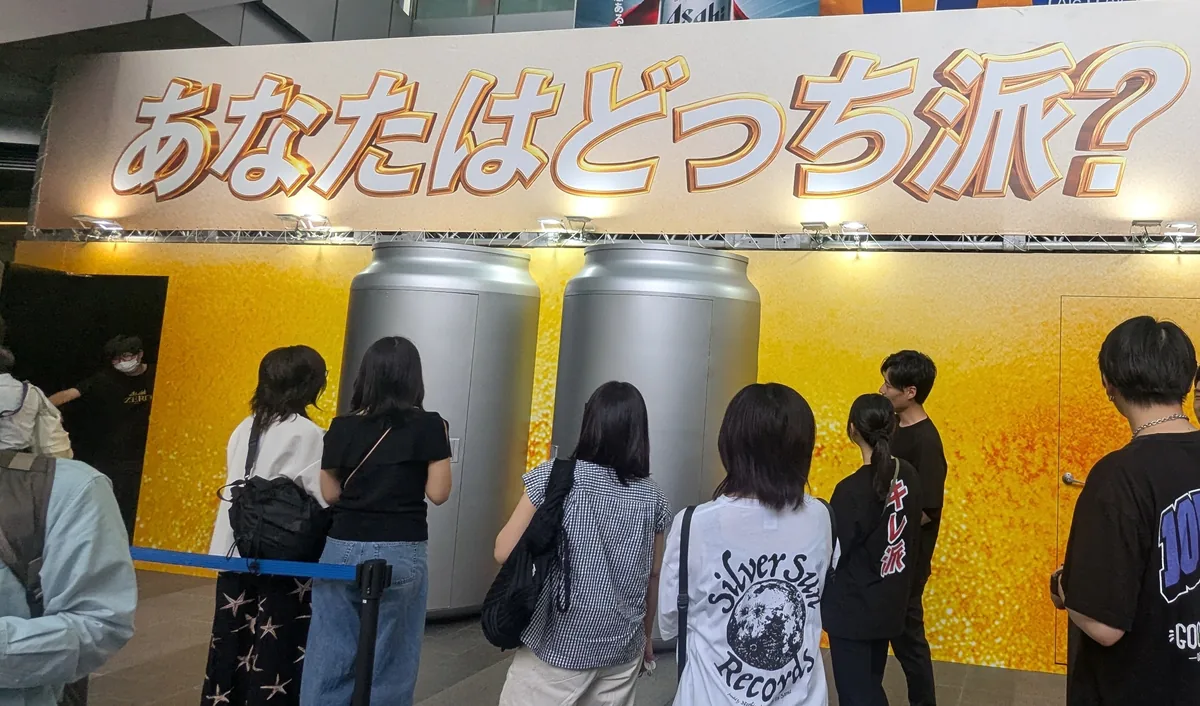 「あなたはどっち派?」の特設ブースに並ぶ来場者と巨大な缶のオブジェ