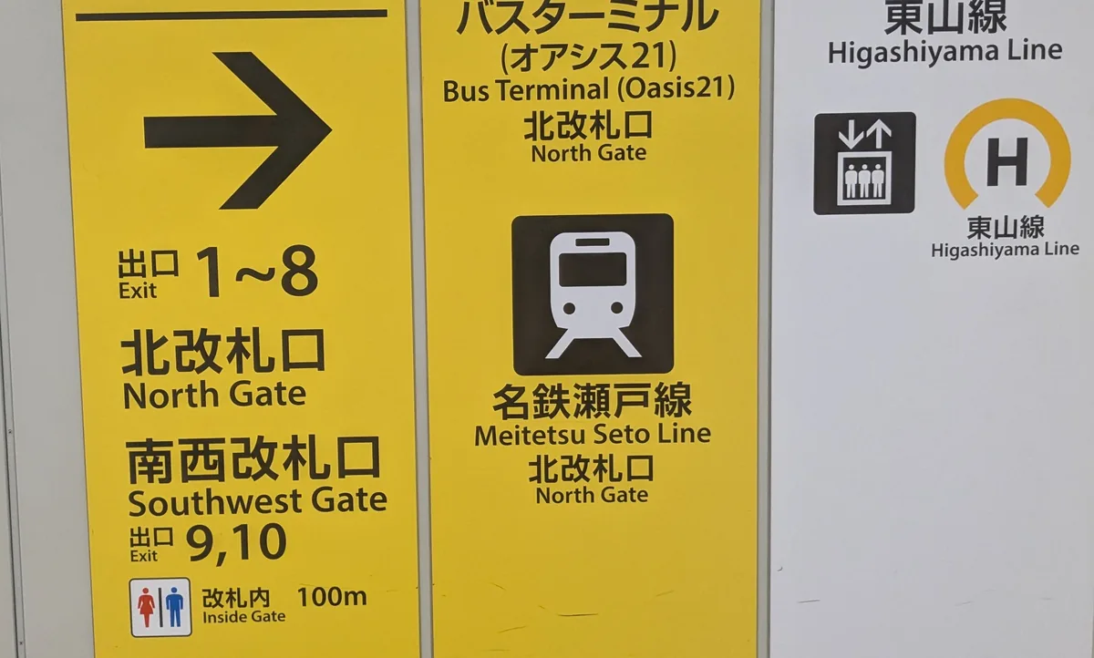 地下鉄栄駅名城線ホームの案内板。北改札口(出口1〜8)と南西改札口(出口9,10)の方向を示す黄色い看板