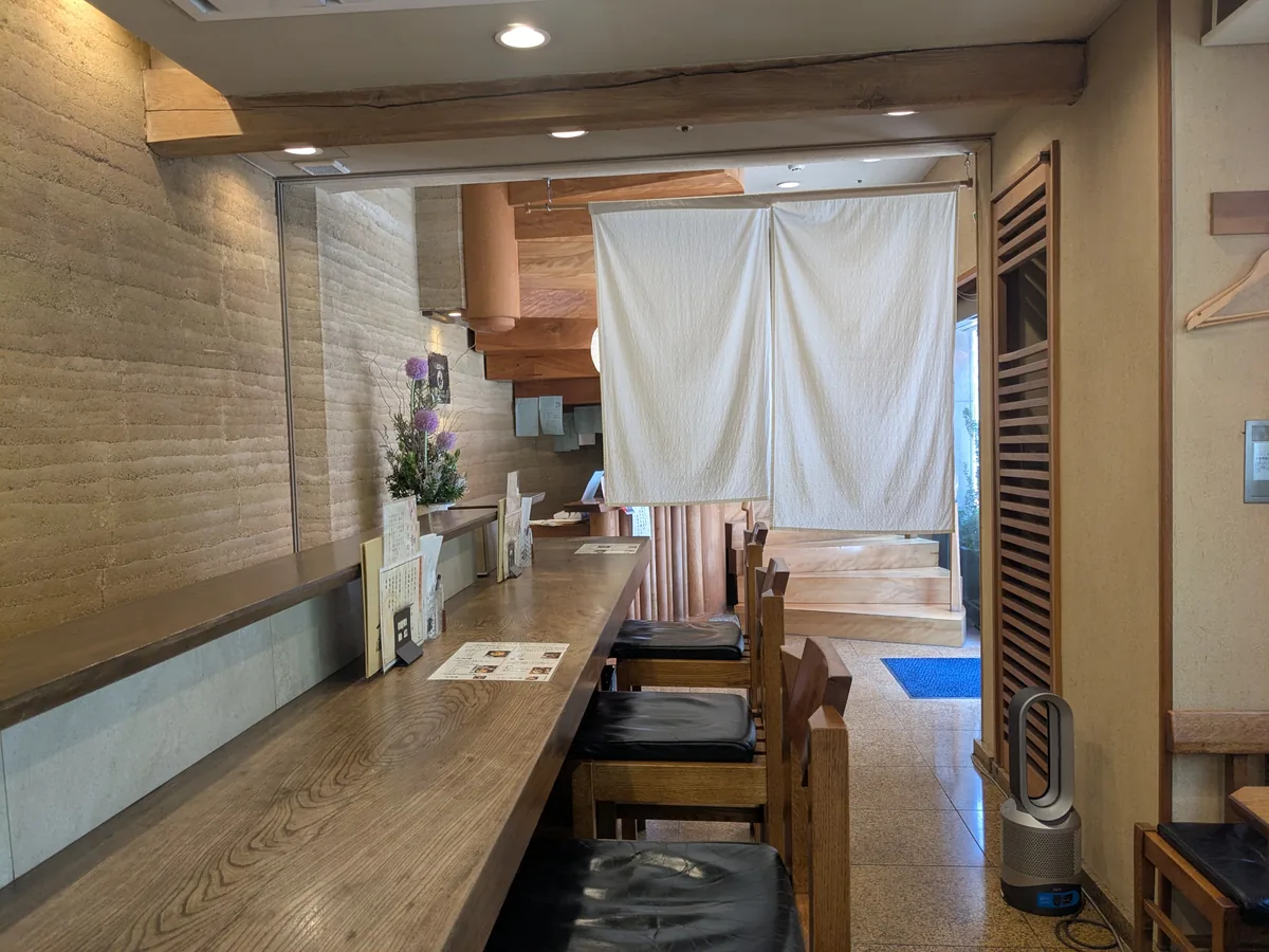 一鳳にしきの店内。土壁と一枚板のカウンターが落ち着いた和の空間