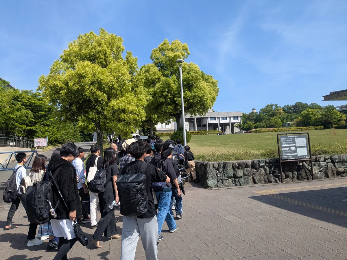 新緑の名古屋大学東山キャンパスを歩く学生たち
