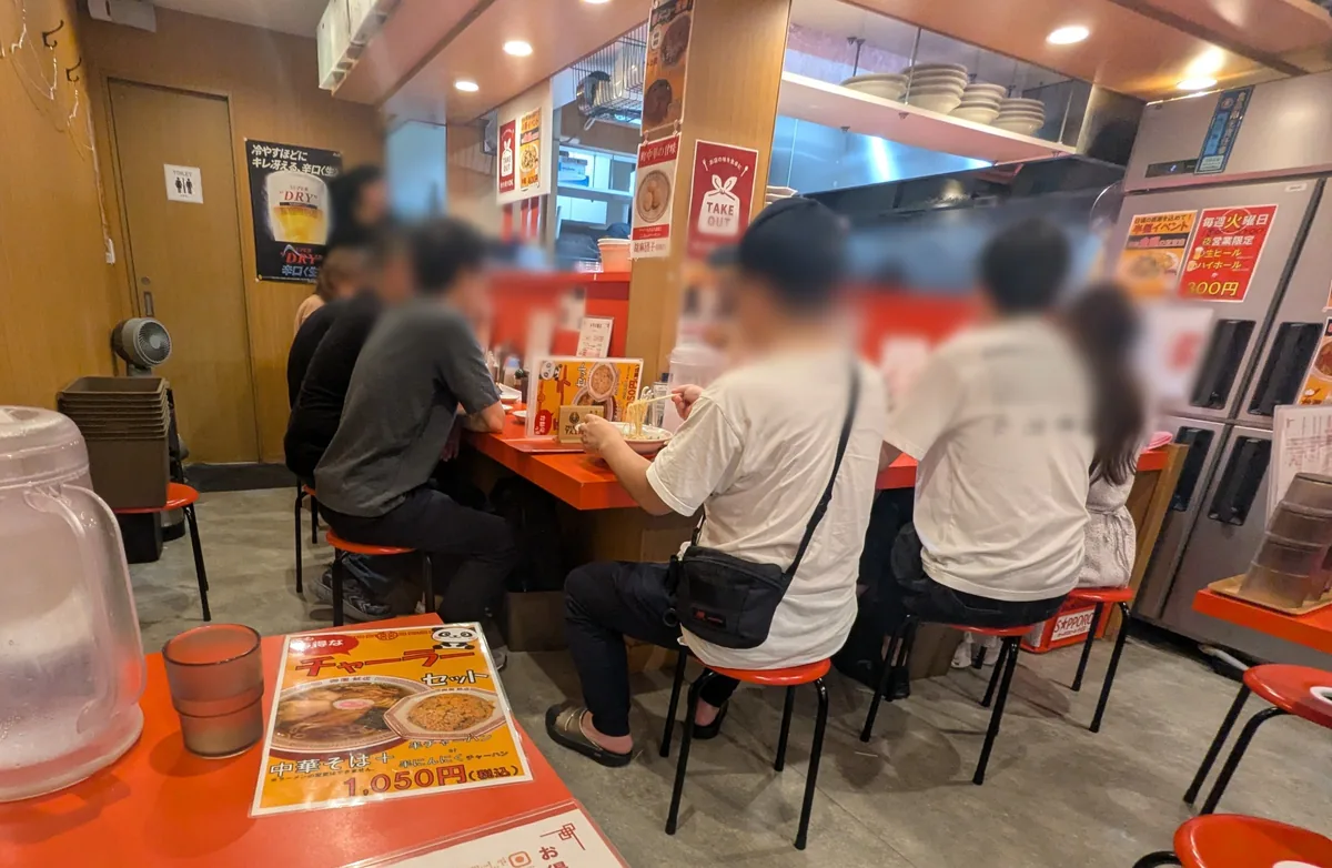 オレンジ色の椅子が並び、お客さんで賑わうみその飯店の店内