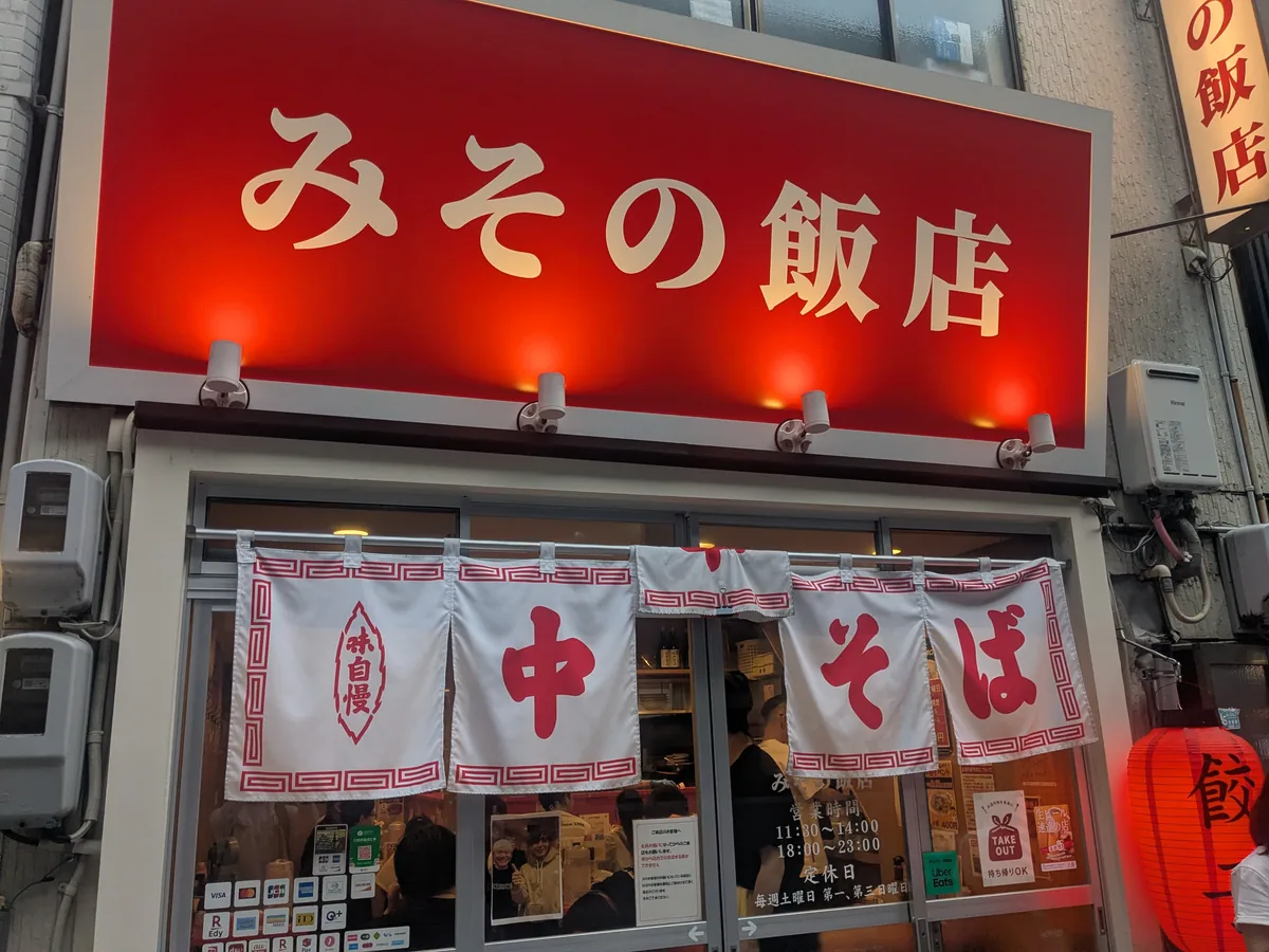 名古屋・栄にある町中華「みその飯店」の赤い看板と「中・そば」の暖簾がかかった外観