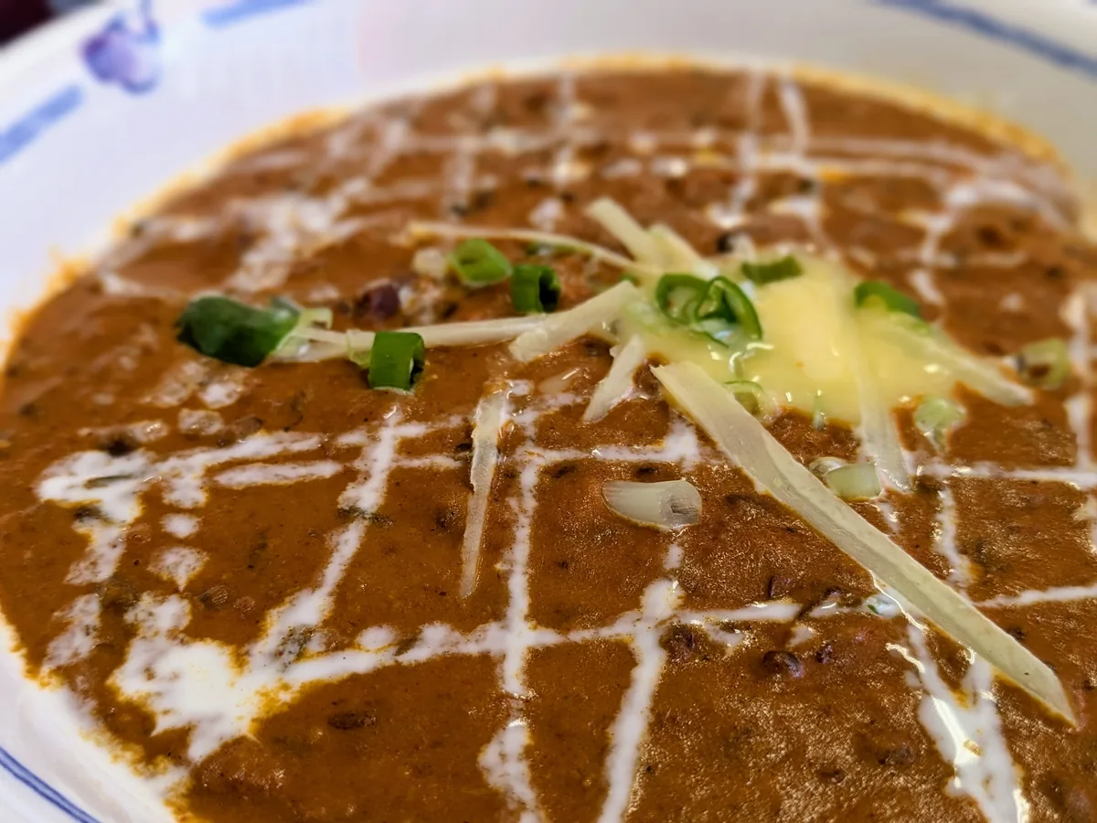 生クリームと青ねぎ・チーズをトッピングしたSAHARAの名物・豆マカニカレー