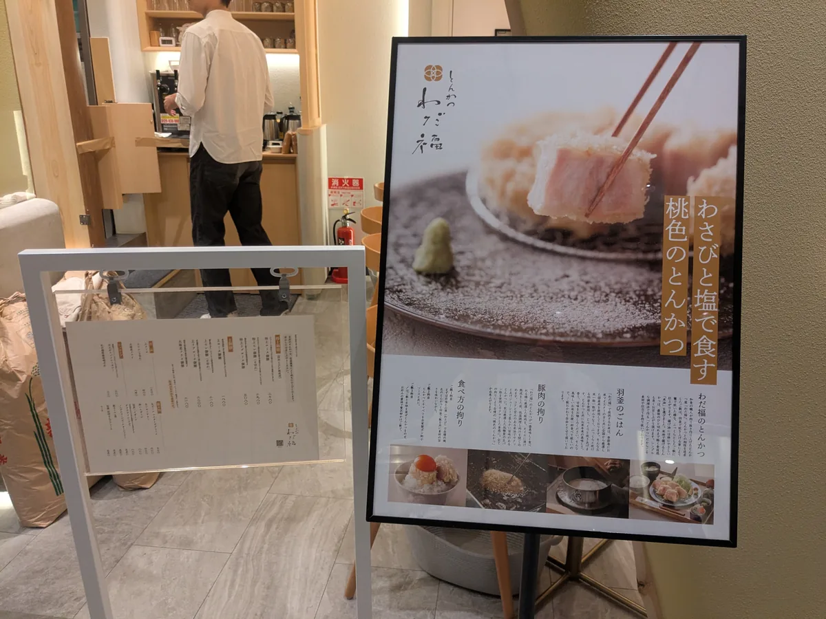 わさびと塩で食す桃色のとんかつを紹介するわだ福のポスター
