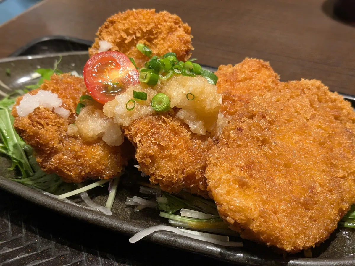 リアルキッチン栄店のチキンカツのおろしポン酢定食のアップ。大根おろしと刻みねぎがのったサクサクのチキンカツ