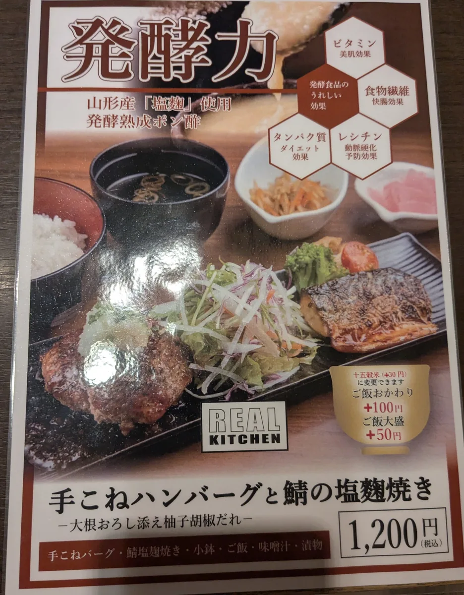 リアルキッチン栄店の看板メニュー、手こねハンバーグと鯖の塩麹焼き定食1200円のポスター