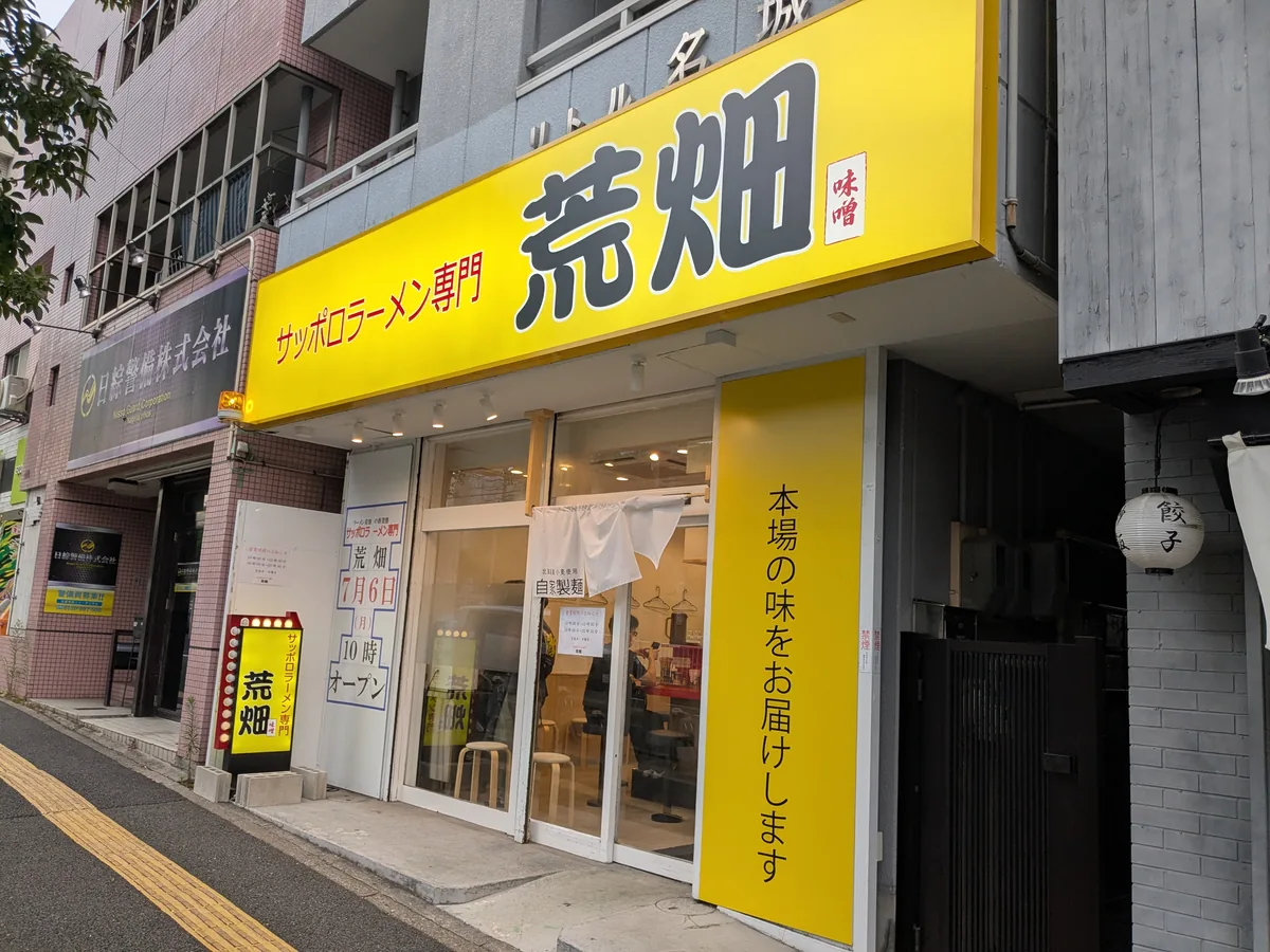 塩釜口駅1番出口すぐにあるサッポロラーメン専門 荒畑の黄色い看板の外観