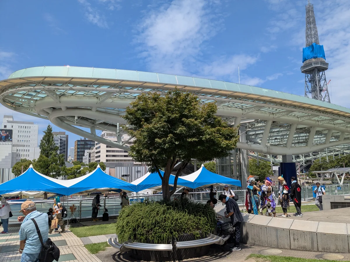 オアシス21の水の宇宙船と中部電力MIRAI TOWERを背景に歩く世界コスプレサミット2026のコスプレイヤー