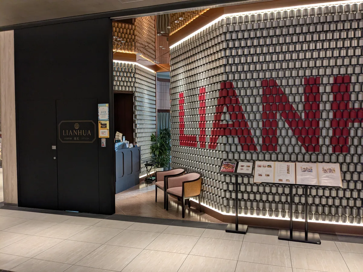 中日ビル3階にあるLIANHUAの入口。茶筒を積み上げた壁に赤い文字でLIANHUAと描かれている