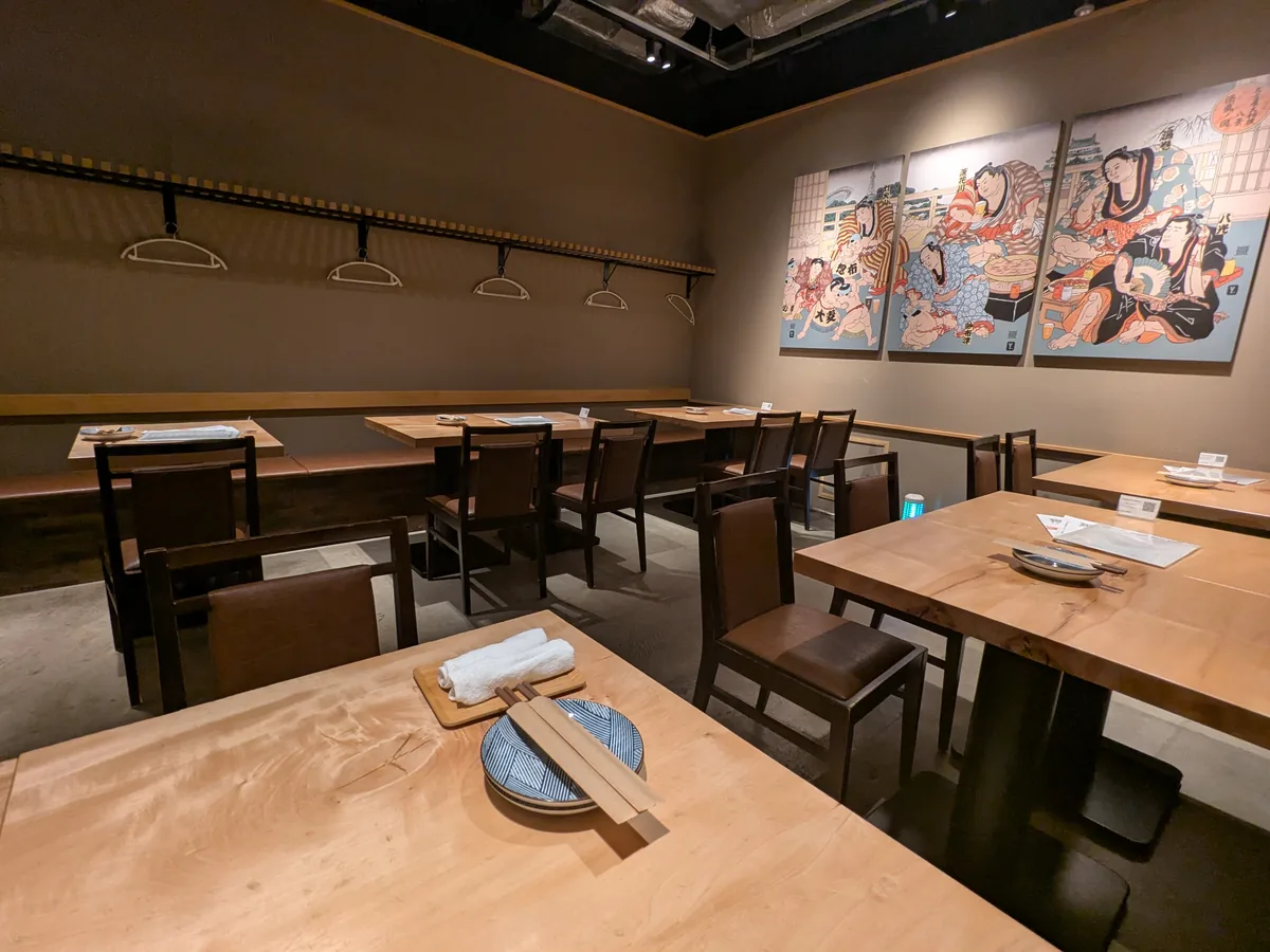 相撲の浮世絵アートが飾られたナゴロバの店内テーブル席