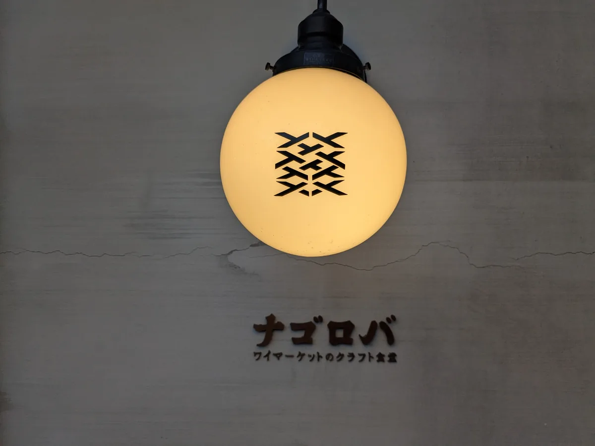 ナゴロバの外壁に灯るロゴ入りランプ