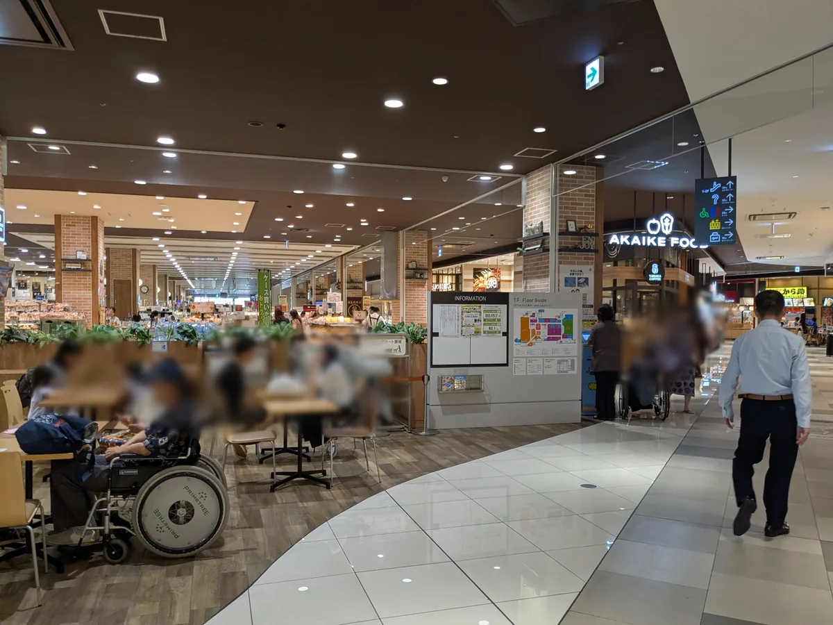 プライムツリー赤池1階のフードゾーンAKAIKE FOOD。イートイン席とフロアガイドの案内板が並ぶ