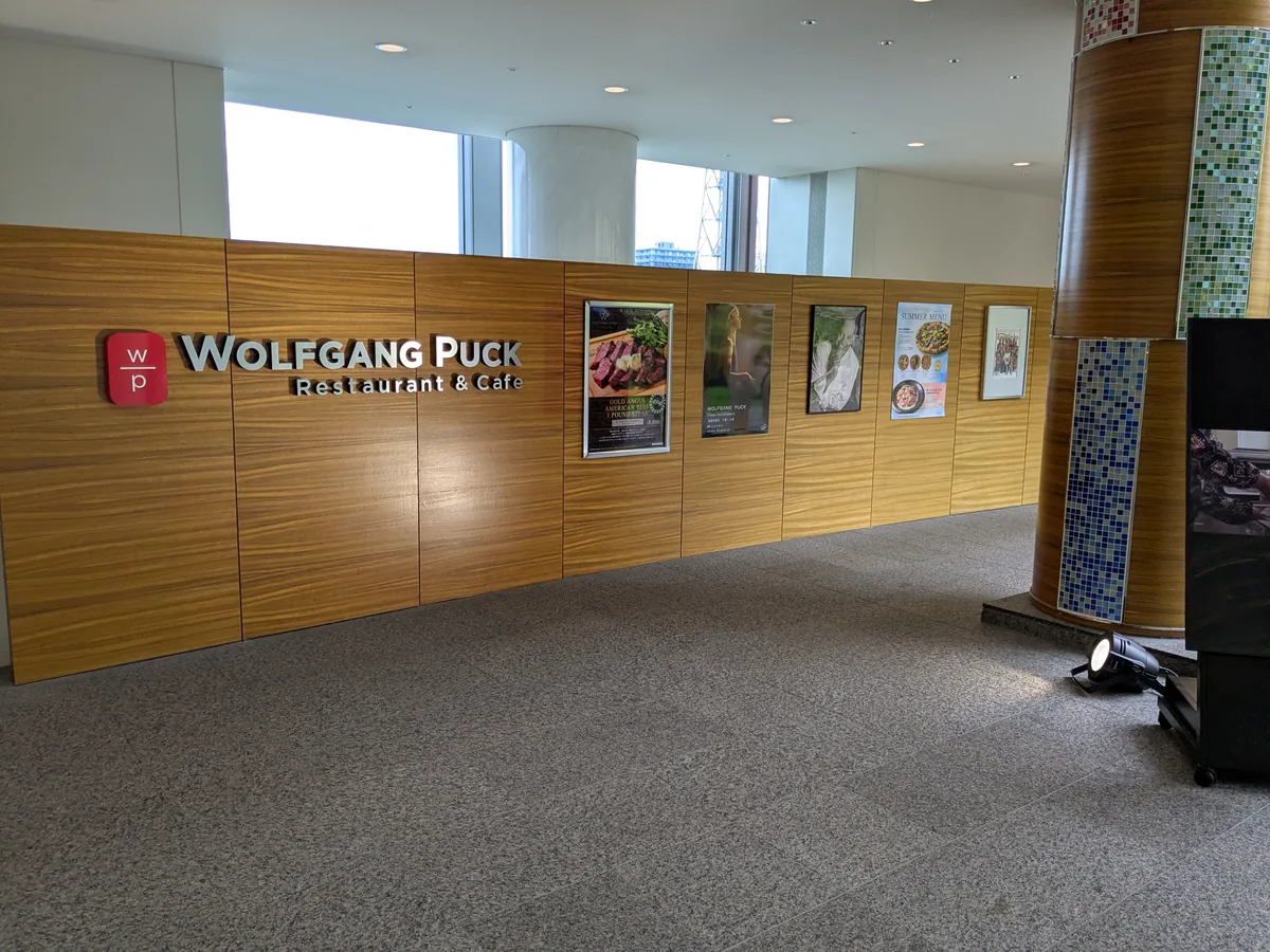 ウルフギャング・パック愛知芸術文化センター店の木目調エントランスとWOLFGANG PUCKのサイン