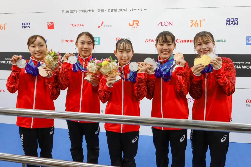 アジア大会 体操女子団体 銀メダルの日本代表5選手がメダルを掲げる。左から岡村真選手、岸里奈選手、中村遥香選手、西山実沙選手、杉原愛子選手