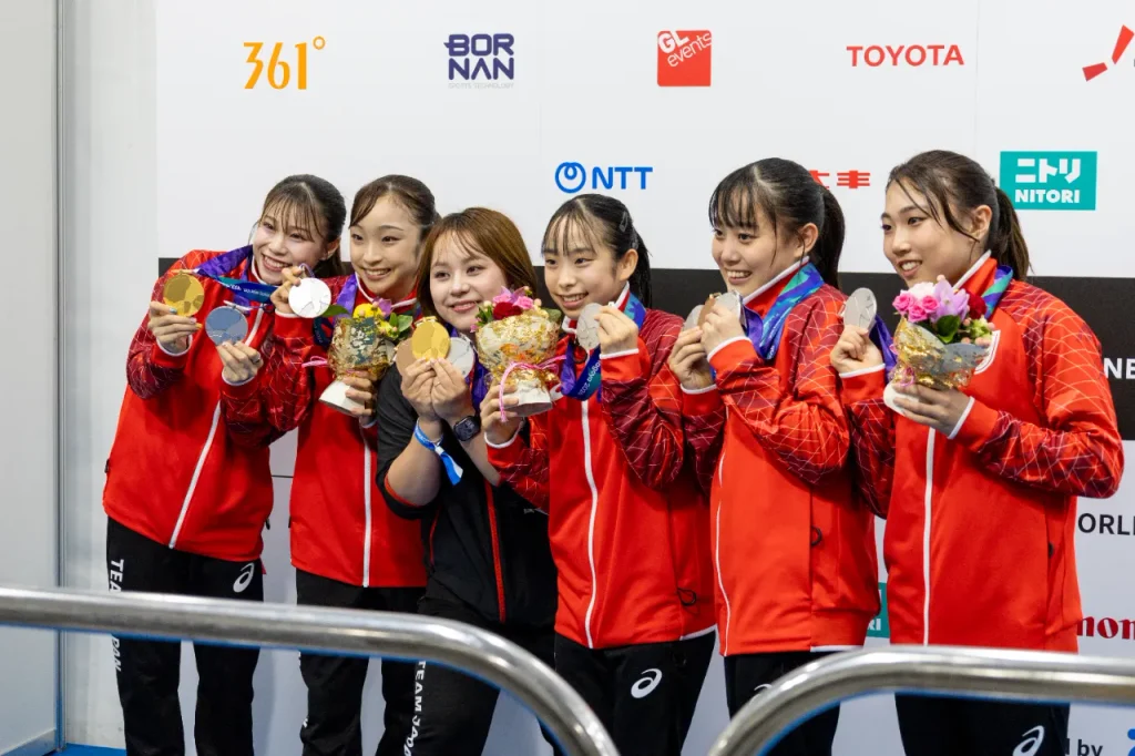女子強化本部長の村上茉愛さんと記念撮影する体操女子日本代表の選手たち