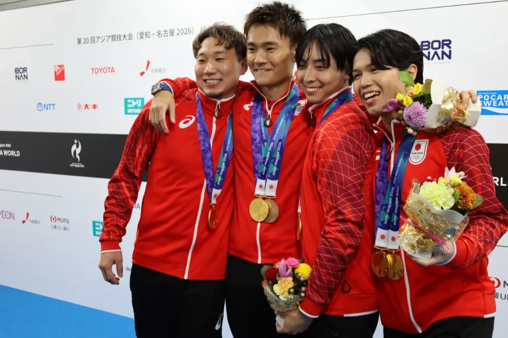 肩を組んで喜ぶフェンシング男子フルーレ団体 金メダルの日本代表。左から西藤俊哉選手、松山恭助選手、馬場俊輔選手、飯村一輝選手