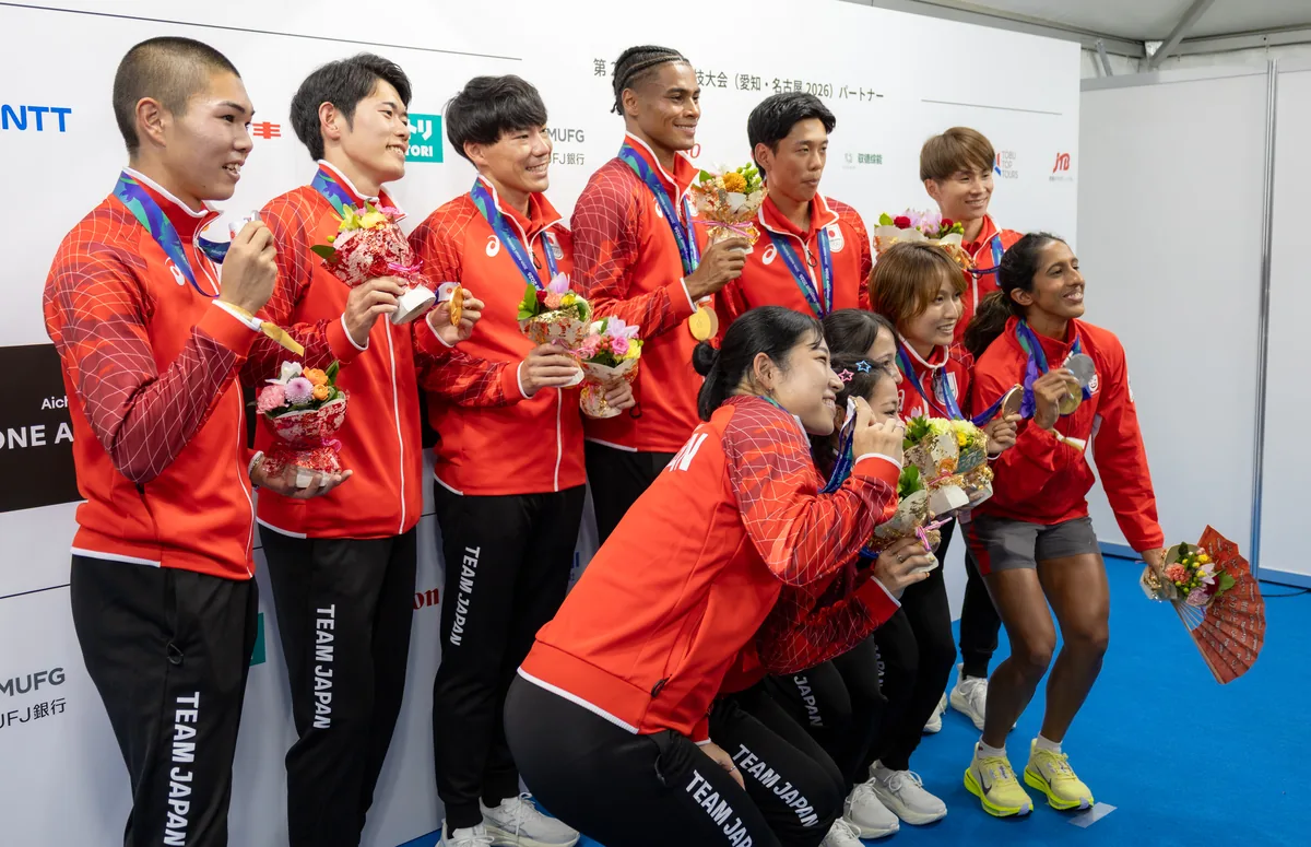 日本の陸上メダリストと並んで撮影に応じるシンガポールのシャンティ・ペレイラ選手