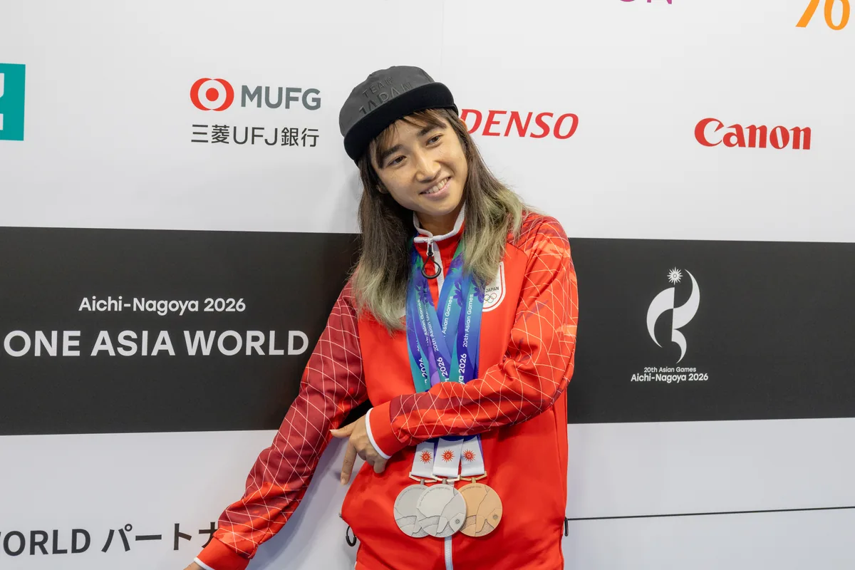 3つのメダルを首にかけてポーズをとる田中希実選手