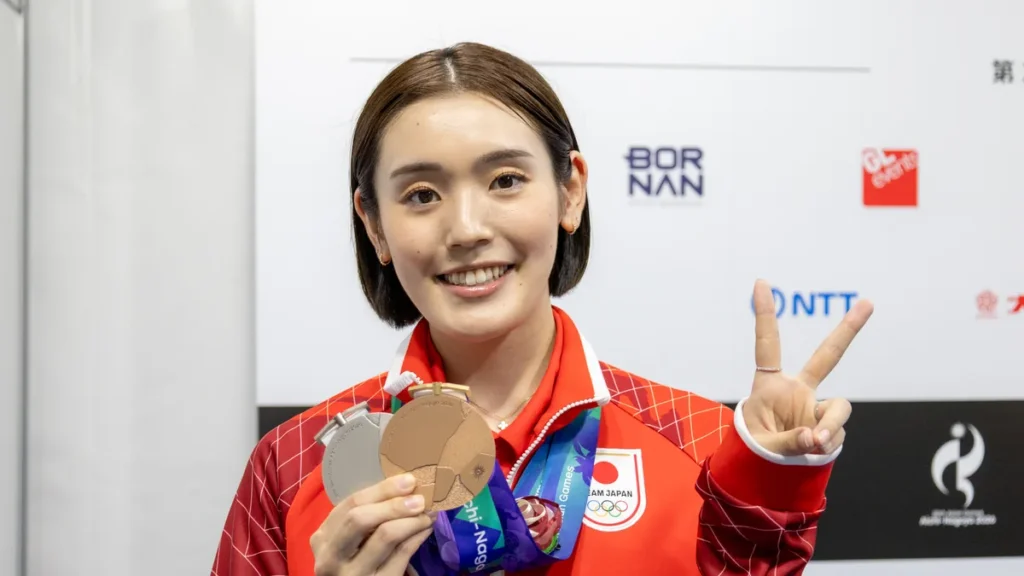 銀メダルと銅メダルを手にピースサインをするバドミントンの岩永鈴選手
