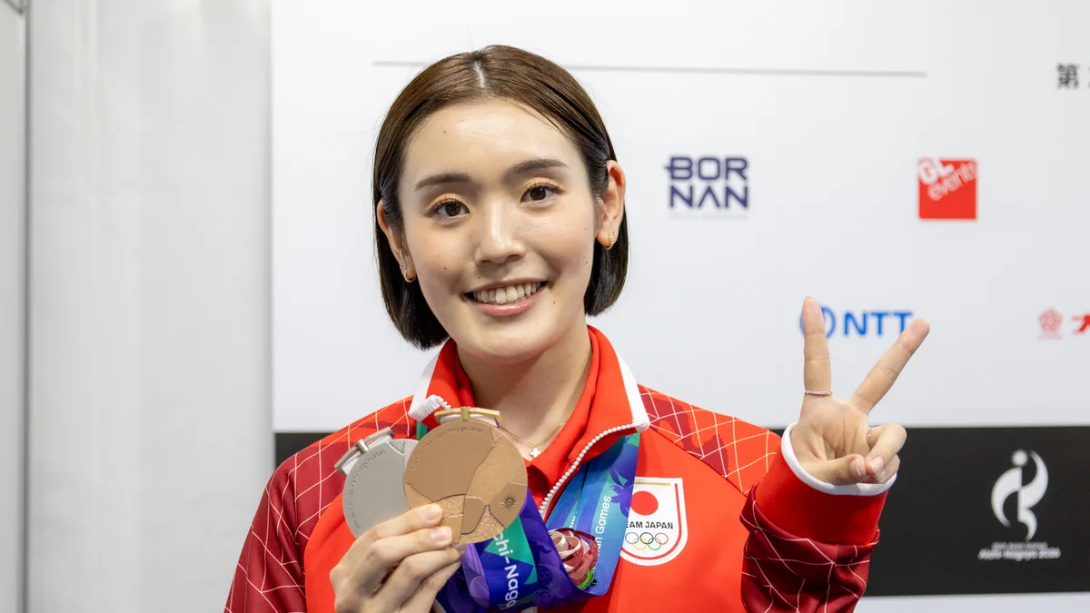 銀メダルと銅メダルを手にピースサインをするバドミントンの岩永鈴選手