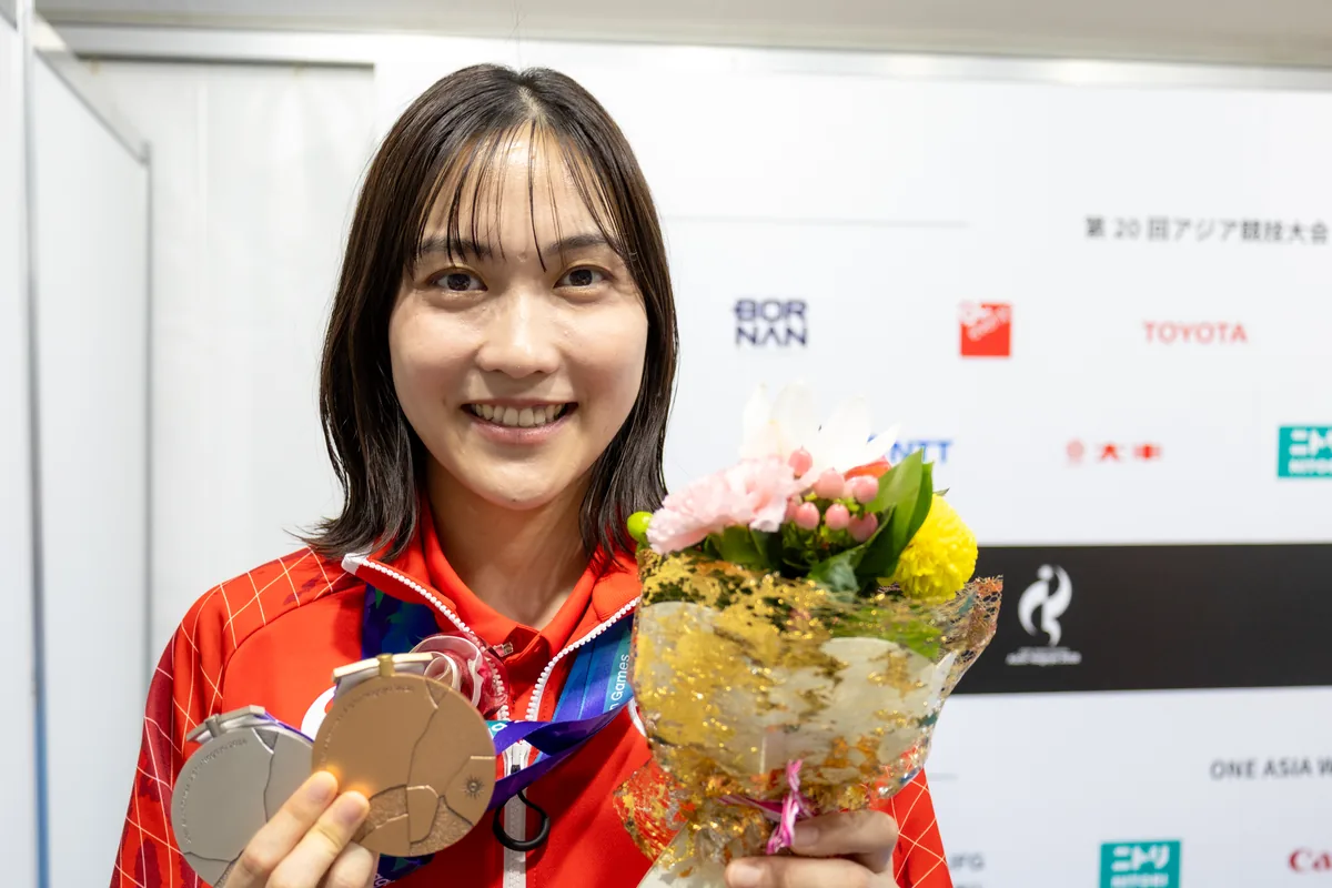 2つのメダルと花束を手に撮影に応じる中西貴映選手