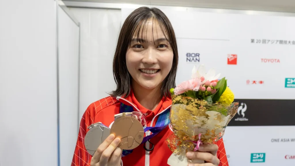 銀メダルと銅メダル、花束を手に笑顔を見せるバドミントンの中西貴映選手