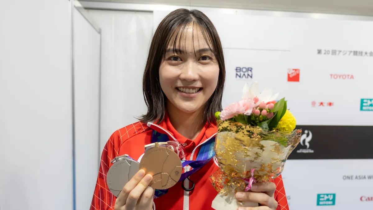 銀メダルと銅メダル、花束を手に笑顔を見せるバドミントンの中西貴映選手