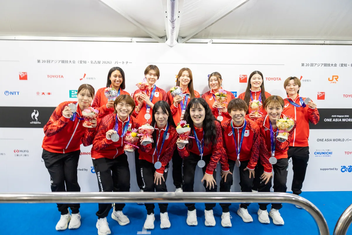 銀メダルと花束を手に記念撮影に応じるバスケットボール女子日本代表の12人