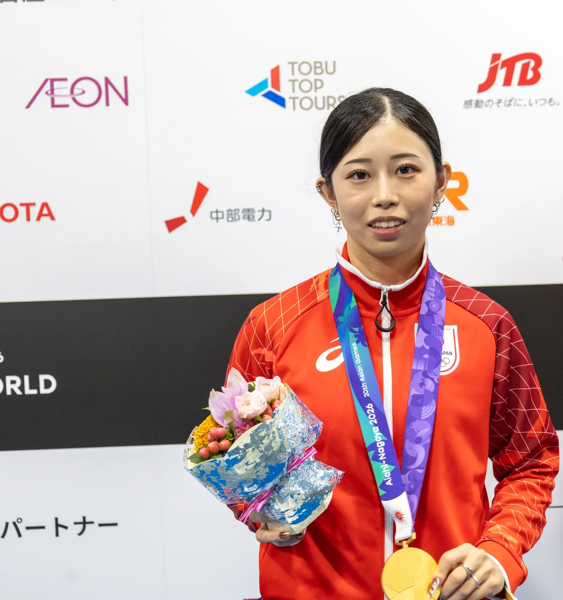 金メダルと花束を手に取材に応じるフェンシング女子フルーレ団体の辻すみれ選手