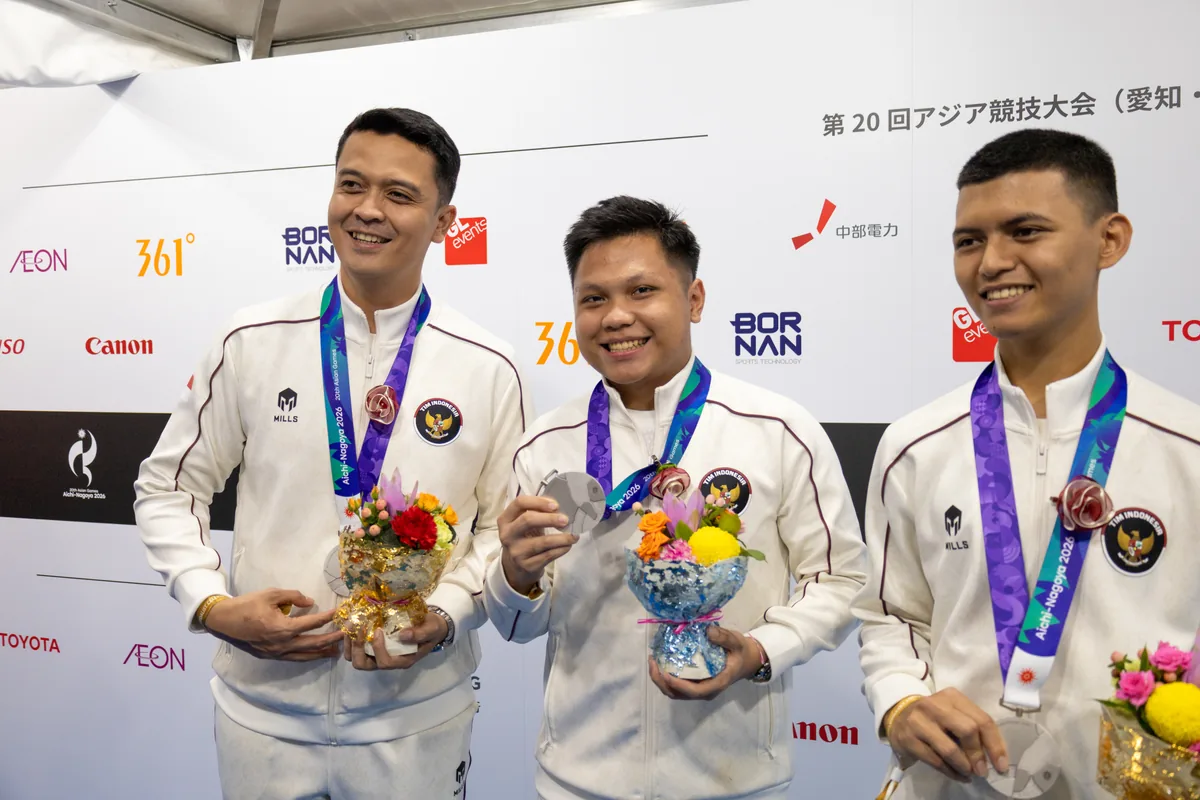 銀メダルと花束を手に並ぶ射撃男子10mエアピストル団体のインドネシア代表3選手