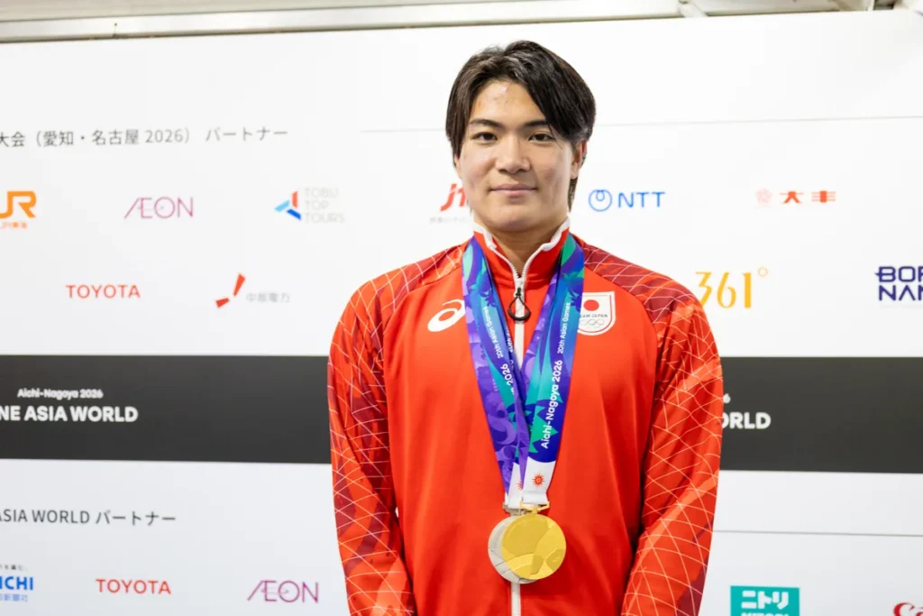 金メダルを胸にほほえむ競泳の松下知之選手