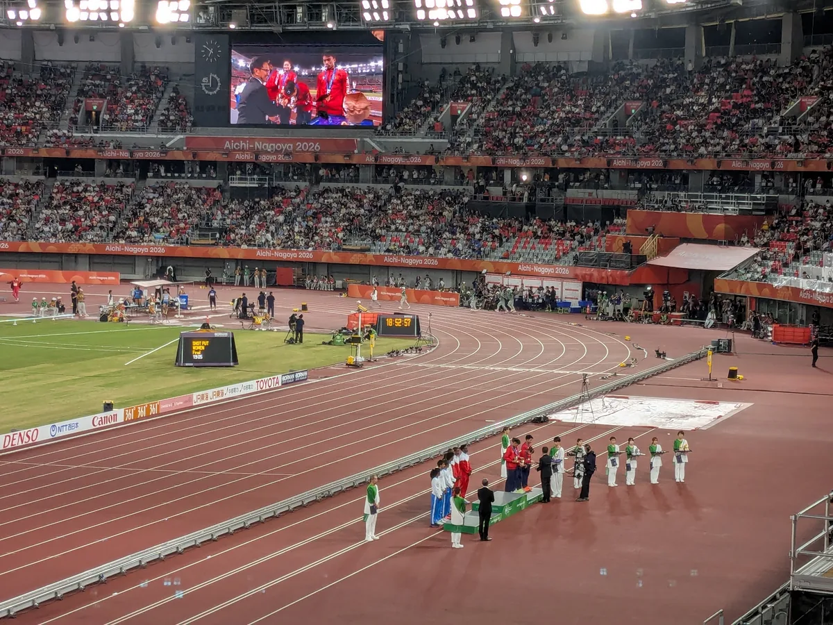パロマ瑞穂スタジアムのトラックで行われた表彰式と大型ビジョンに映るメダリスト