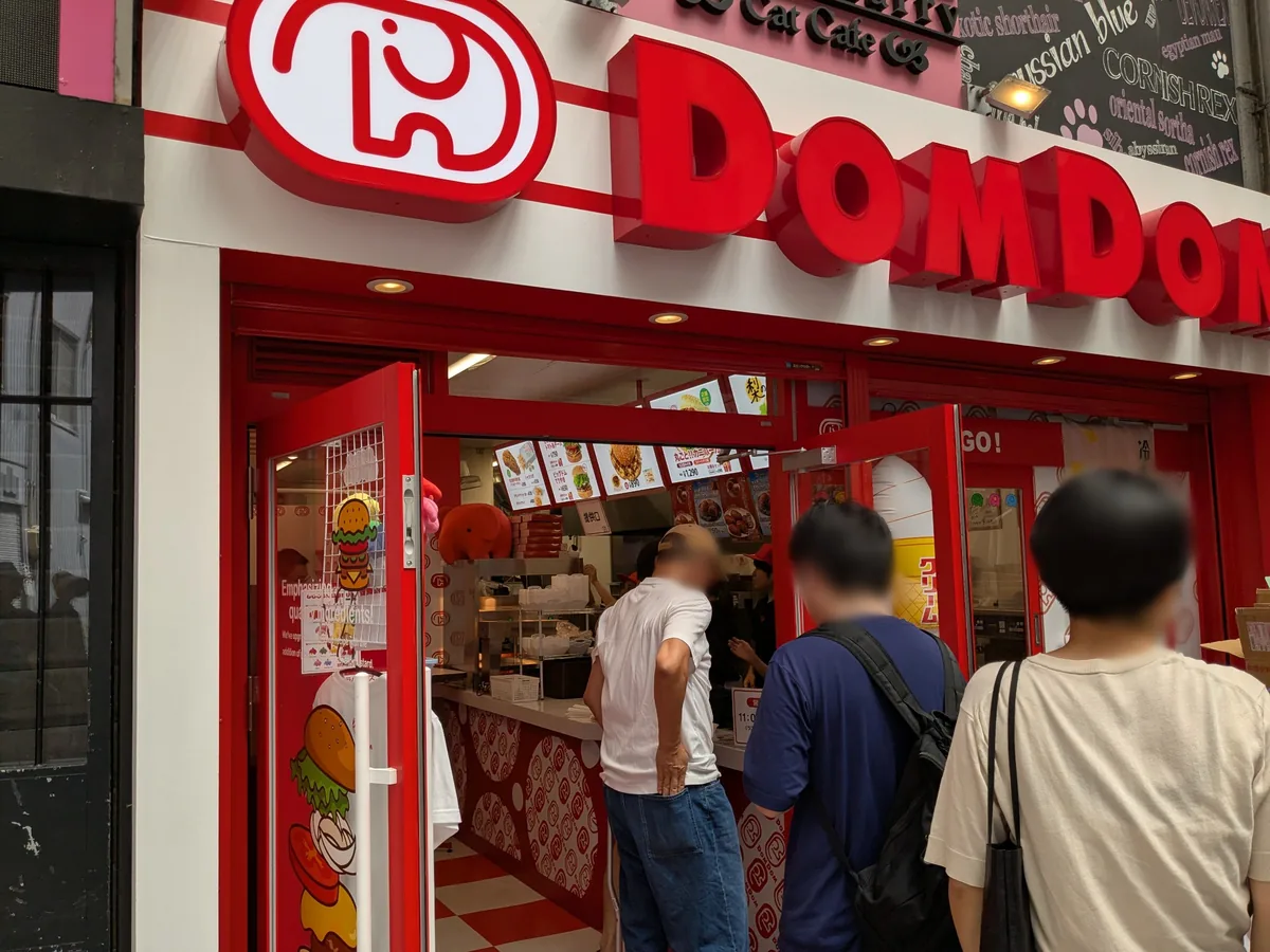 DOM TO GOの表示があるドムドムハンバーガー大須万松寺通店の入口と注文カウンター