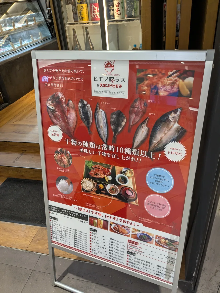 名駅ユニモールにあるヒモノ照ラス&スタンドヒモ子の店頭看板。干物の種類は常時10種類以上
