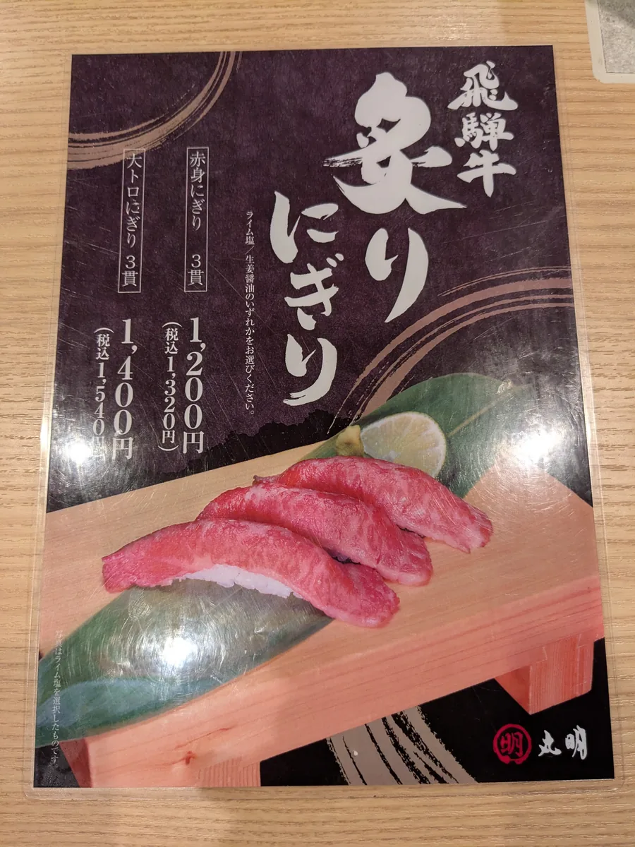 丸明 茶屋ヶ坂店の飛騨牛炙りにぎりの案内。赤身3貫1,320円、大トロ3貫1,540円