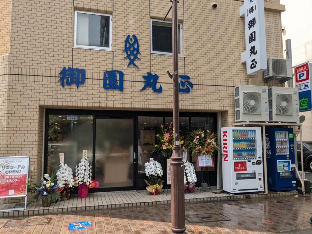 2026年9月14日にリニューアルオープンした御園丸正本店の外観。祝花が並ぶ伏見・御園通の店舗