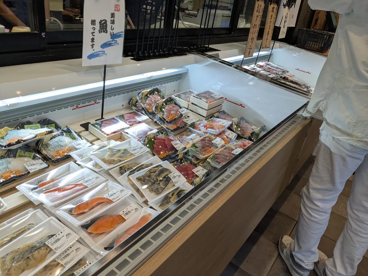 御園丸正の鮮魚ケース。お刺身盛り合わせ、あおりいか、銀サケ、サワラ西京漬けの切り身が並ぶ