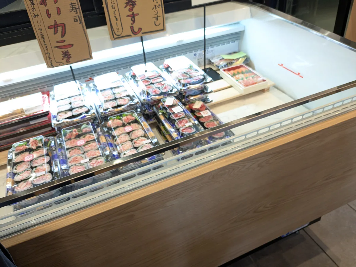 御園丸正の寿司ケースに並ぶ具たっぷりまぐろ巻すしと紅ずわいカニ巻