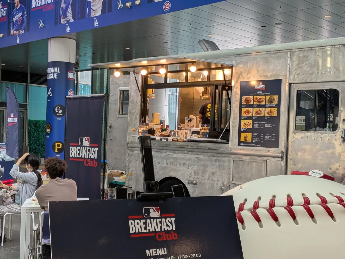 MLB Breakfast Clubのシルバーのフードトラック。カウンターでバーガーやドリンクを提供