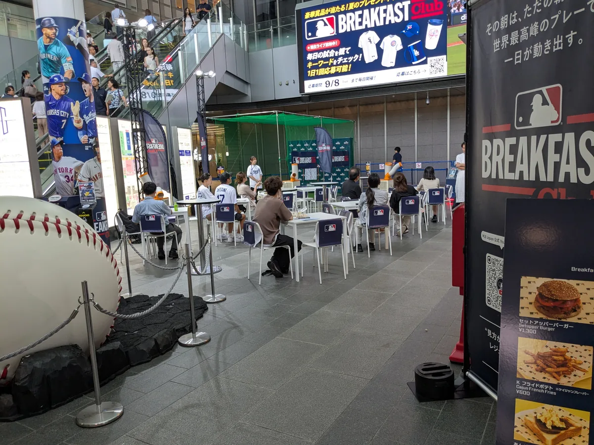 MLB Breakfast Clubの観戦席。巨大なボールのオブジェと大型ビジョン、奥にストラックアウトのネット