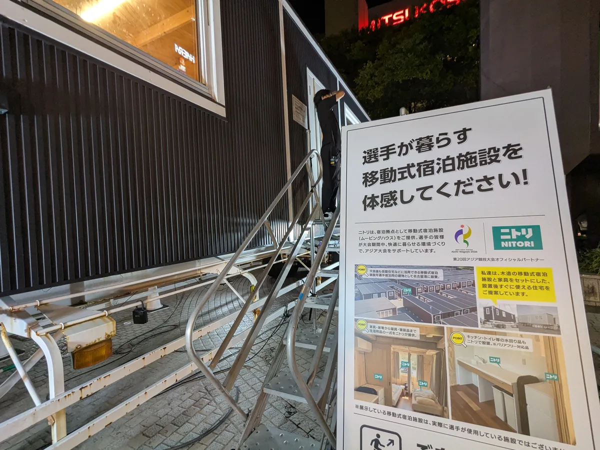 サカエ ヒロバスに展示されたニトリの移動式宿泊施設(ムービングハウス)。「選手が暮らす移動式宿泊施設を体感してください!」のパネル