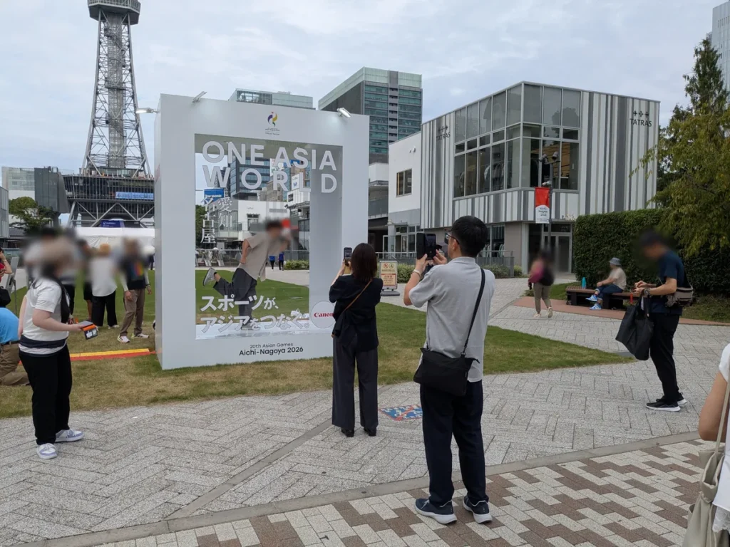 「スポーツが、アジアをつなぐ。」と書かれたONE ASIA WORLDの巨大フォトスポットで記念撮影する来場者
