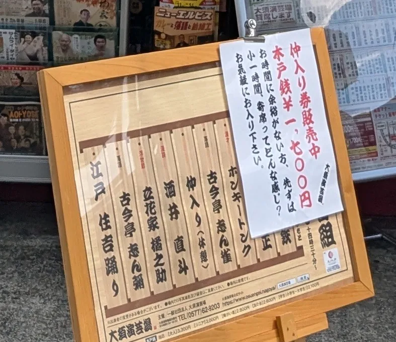 大須演芸場の入口に掲示された「仲入り券販売中 木戸銭700円」の案内と当日の番組表