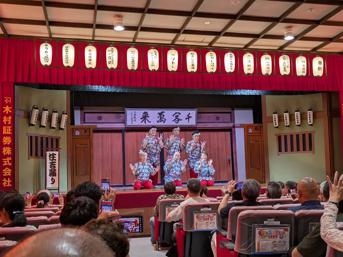 大須演芸場のフィナーレ「江戸住吉踊り」。揃いの浴衣に赤い袴の出演者6人が「千客萬来」の額の前で手を振る
