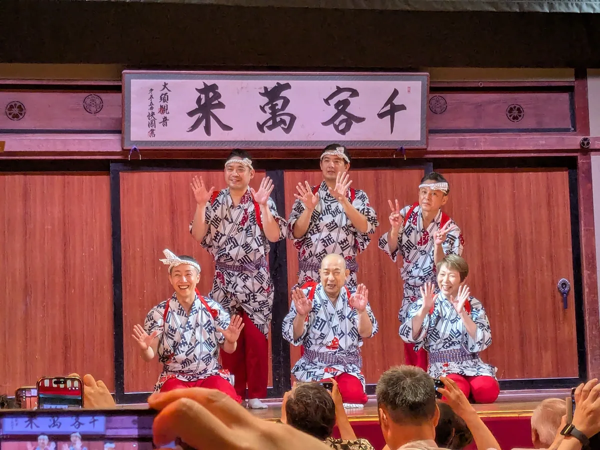 住吉踊りを終えて笑顔で手を振る大須演芸場の出演者たち。客席からはスマホでの撮影が一斉に