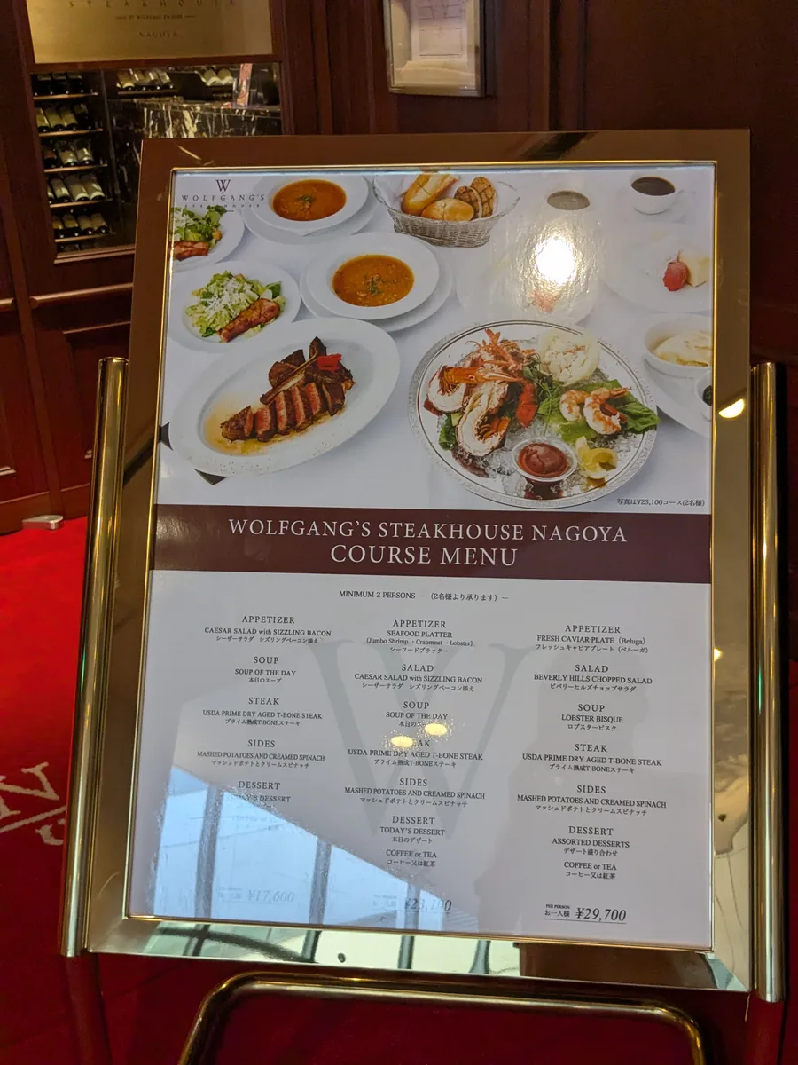 ウルフギャング・ステーキハウス名古屋店のコースメニュー看板。1人17,600円・23,100円・29,700円の3コース、2名から