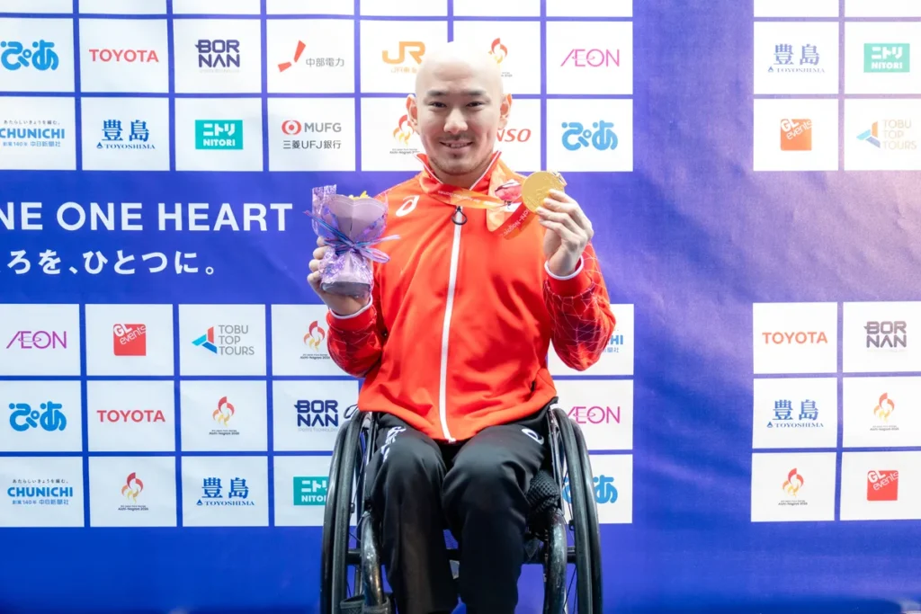 金メダルと花束を手にする車いすバスケットボール男子の赤石竜我選手
