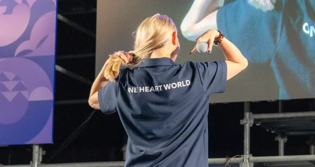 ONE HEART WORLDのシャツの背中のロゴを観客に見せる安藤美姫さん