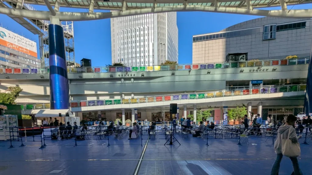 オアシス21 銀河の広場に設けられたライブサイトの観客席。周囲の回廊にAichi-Nagoya 2026の旗が並ぶ