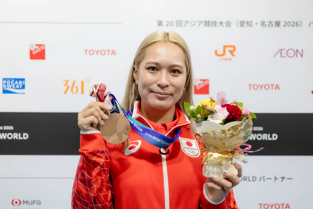 銅メダルと花束を手にほほえむ女子やり投の武本紗栄選手